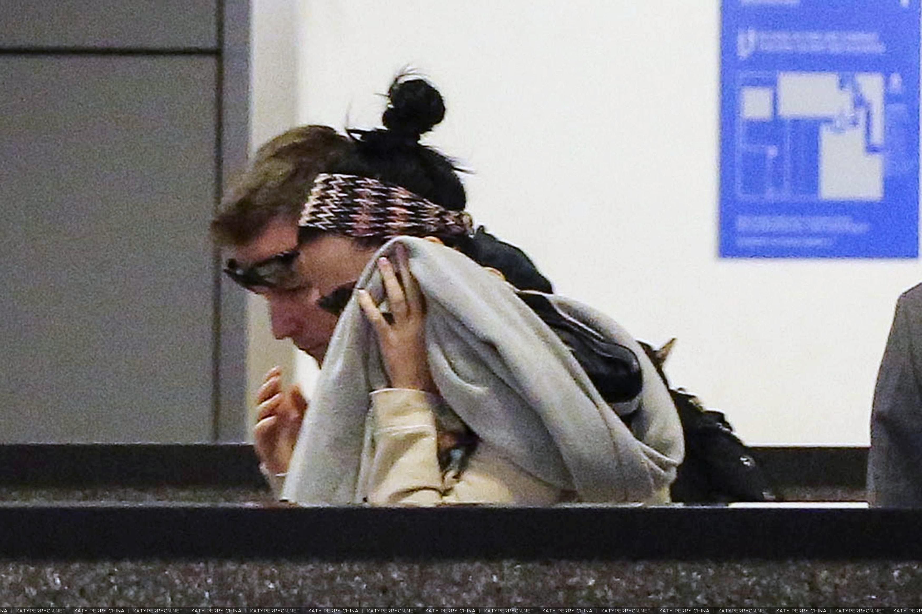 凯蒂佩芮抵达洛杉矶国际机场，躲在保镖和航空公司迎宾员身后